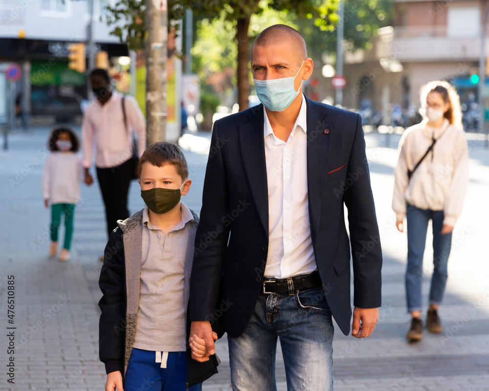 Fototapeta premium caucasian man and boy in masks on city street