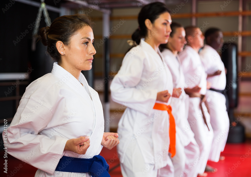 Karate or taekwondo training athletes in kimono stand in a fighting