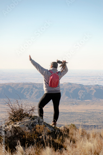 young brunette woman goes trekking on a mountain