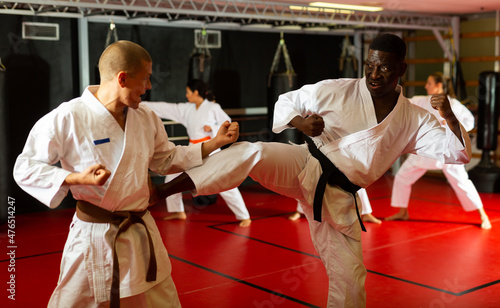 Two man in kimono fighting with each other in gym