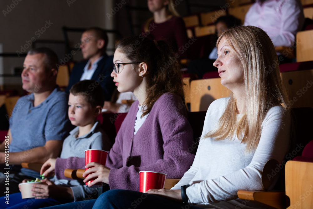 parents with children sitting at movie in cinema