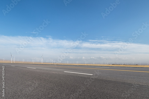 empty asphalt road with wind farm