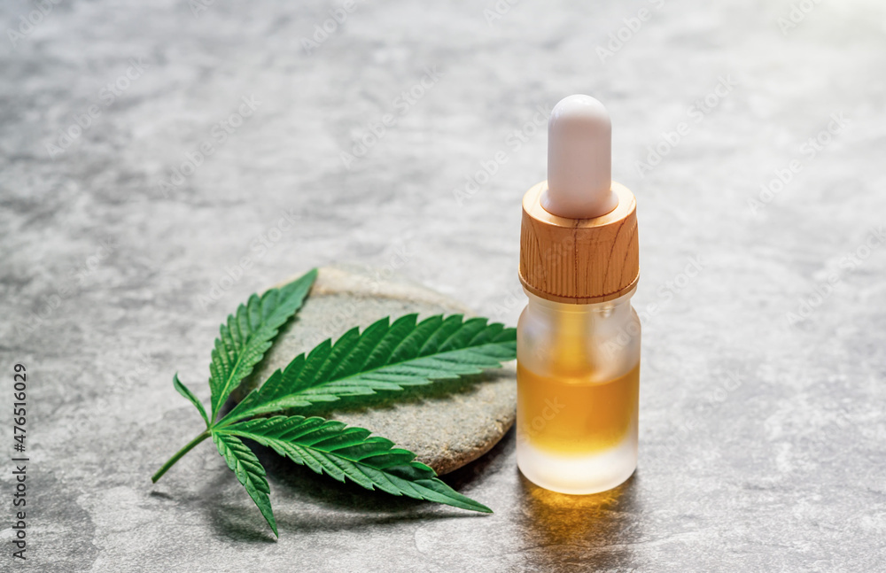 CBD or THC full spectrum medical Cannabis oil on stone table with Hemp leaf copy space CBD or THC full spectrum medical Cannabis oil on stone table with Hemp leaf copy space