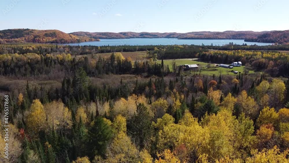 Drone flies an aerial over forest cabin and trees in fall colors. Drone flies an aerial over forest cabin and trees in fall colors.