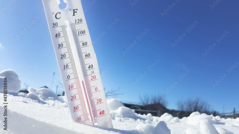 Fototapeta premium Thermometer in winter in the cold on snow and analyzes low negative air temperatures in clear sunny weather.Meteorological conditions and environmental analysis.Climate change on earth.Northern region