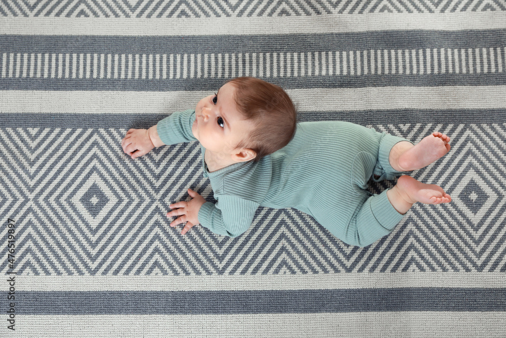 Naklejka premium Cute baby crawling on floor, top view