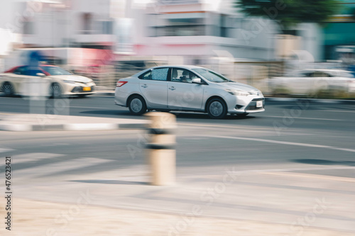Fast-moving cars and delivery vans with a blurry background in Dubai street