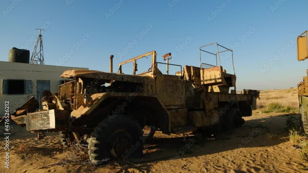 Scrap of military truck in desert area with weeds around it Scrap of military truck in desert area with weeds around it