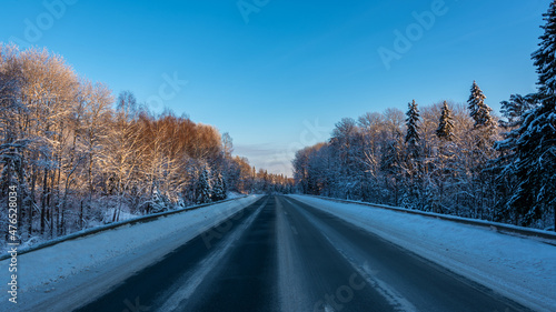 Country road among the winter forest covered with white snow. © Andrey Nikitin