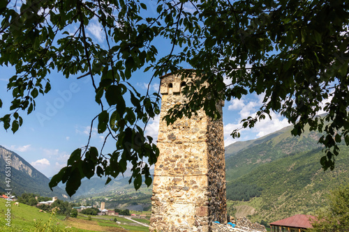 A close up on a lookout tower in Zhabeshi, small village in Georgian mountains. The view on the tower is disturbed by tree branches. Clear and blue sky in the back. Idyllic landscape. photo