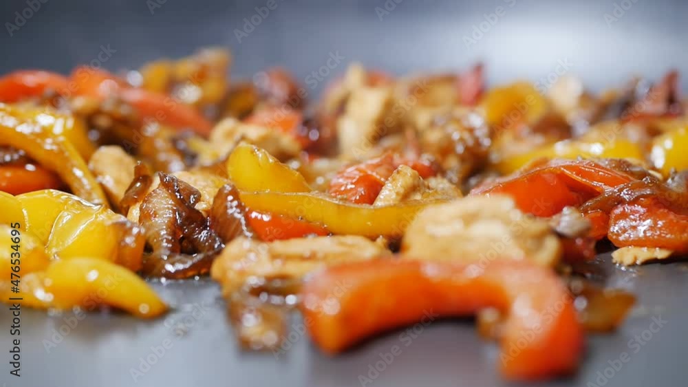 Detail, dolly shot, DOF: Fry red and yellow bell peppers with onions and meat in a pan to add to Korean noodles with spices Detail, dolly shot, DOF: Fry red and yellow bell peppers with onions and meat in a pan to add to Korean noodles with spices