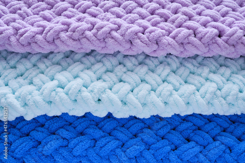 Background, warm, delicate and plush handmade baby blankets in colors of blue, lilac and mint.