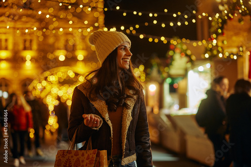 Smiling young woman buying gifts at Christmas market