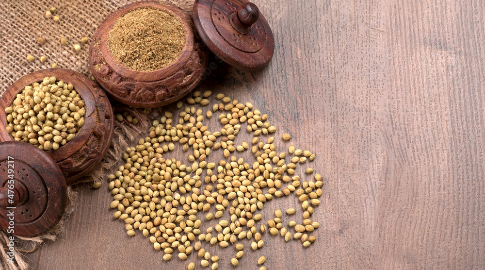 Dry coriander seeds with small bamboo spoon and green fresh bunch coriander leaves,famous spices ingredients in asia's kitchen. Dry coriander seeds with small bamboo spoon and green fresh bunch coriander leaves,famous spices ingredients in asia's kitchen.