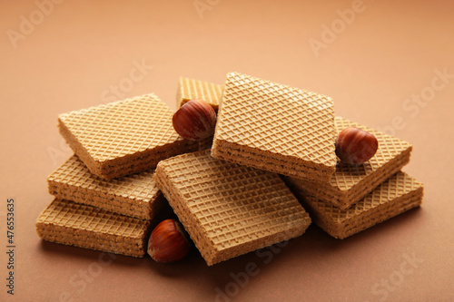 Chocolate wafers on brown background with hazelnut.