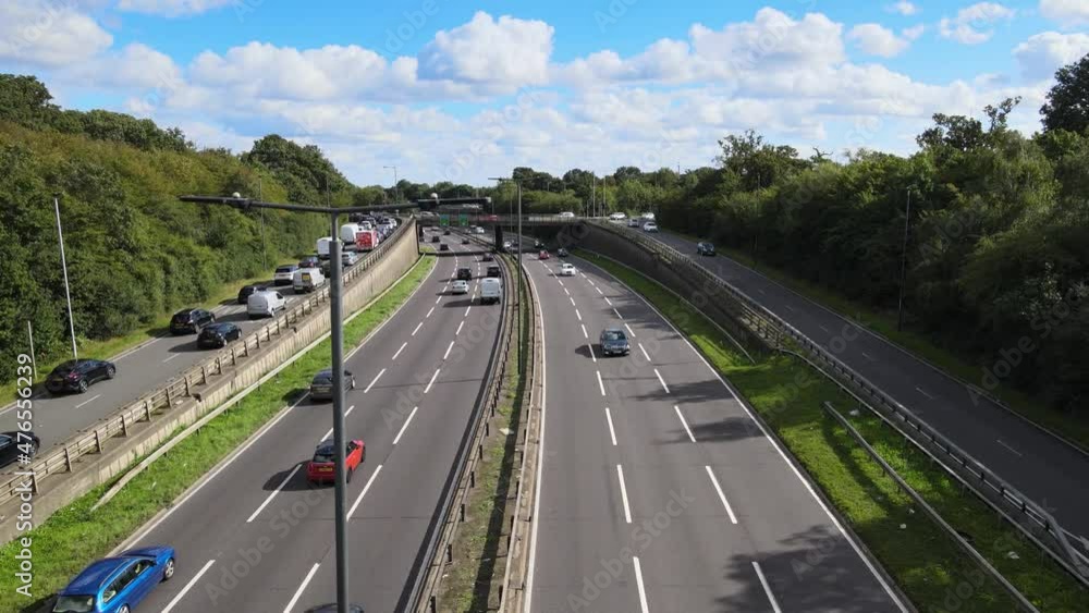 wide multilane highway with exit and on-ramp. Traffic on important road on sunny day. Woodford, London, UK. wide multilane highway with exit and on-ramp. Traffic on important road on sunny day. Woodford, London, UK.