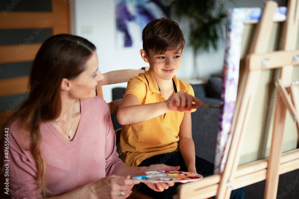 Obraz premium Mother and son painting at home. Little boy drawing with mom in living room