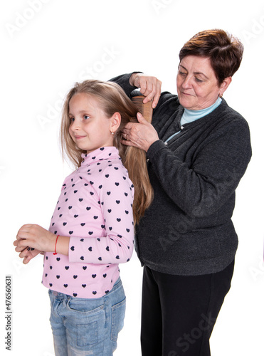 Grandmother combing her beautiful granddaughter