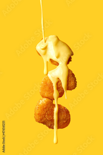 Schilderij op canvas Levitating chicken nuggets topped with cheese sauce