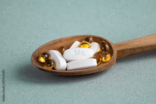 A complex of Mg ( magnesia, magnesium ) and vitamin D ( omega 3 ) capsules for treatment and human health on a light background. Copy space.