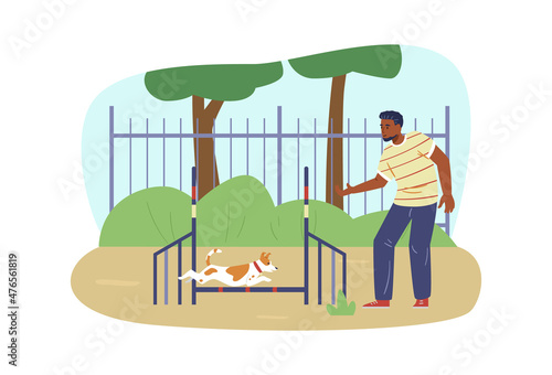 African american man training his Jack Russell Terrier dog on agility field. Dog jumping on agility course.