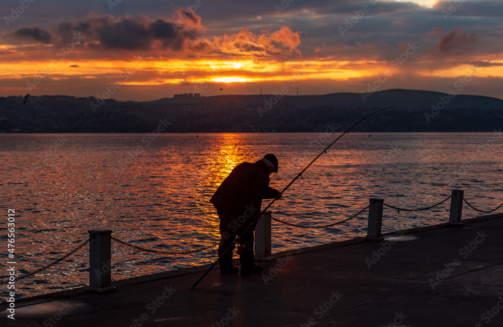 fisherman fishing on Bosporus İstanbul on a Foggy sunrise. Fishing rods on seaside. People jogging on coast. people walking in morning