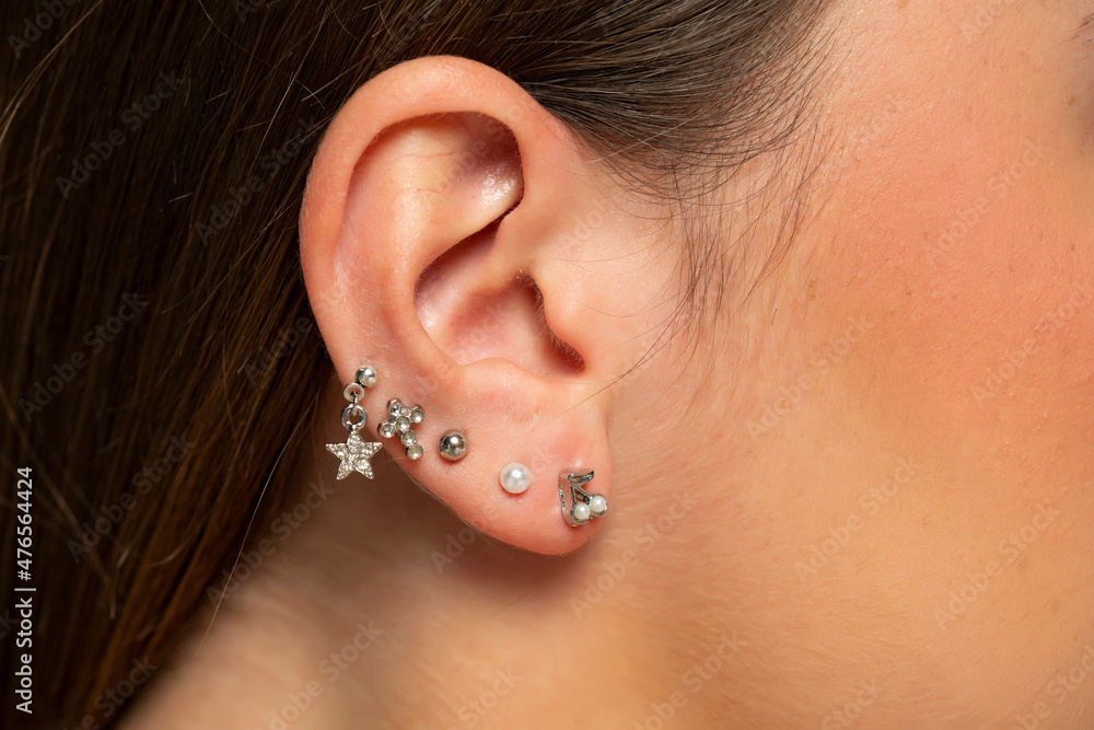 ear piercings photos.Helix piercing.Ear rings - obrazy, fototapety, plakaty 