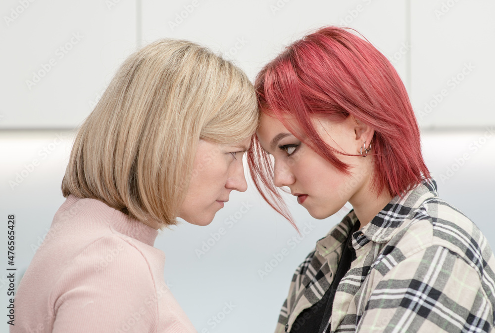Angry mother and her teen daughter look at each other face to face. Family relationships. Concept confrontation of generations Angry mother and her teen daughter look at each other face to face. Family relationships. Concept confrontation of generations