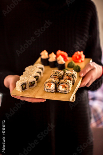 Sushi rolls Japanese delicacies. Japanese traditional rice and fish dishes. Beautiful serving food on a dark background with copy space. A set of delicious goodies.