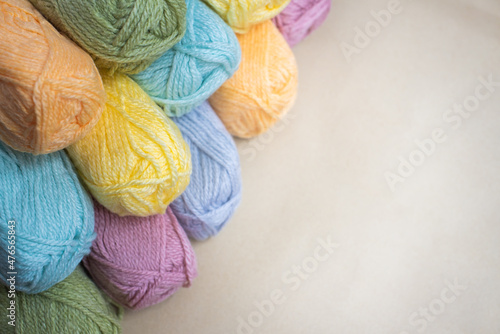 Close Up of yarn balls. Rainbow colors. Yarn for knitting. Skeins of yarn. Knitting needles, colorful threads. Knitting background, Knitting yarn for handmade winter clothes. pastel colors background.