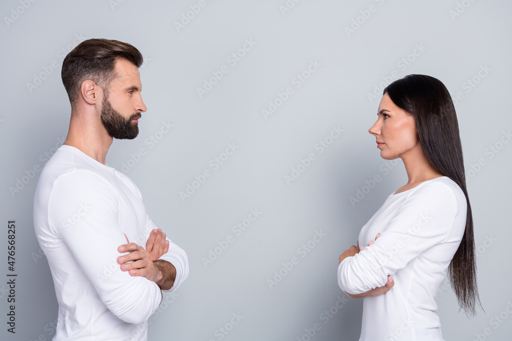 Photo of attractive confident sister brother wear white shirts hands crossed looking each other isolated grey color background Photo of attractive confident sister brother wear white shirts hands crossed looking each other isolated grey color background