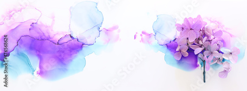Creative image of pastel violet and pink Hydrangea flowers on artistic ink background. Top view with copy space photo