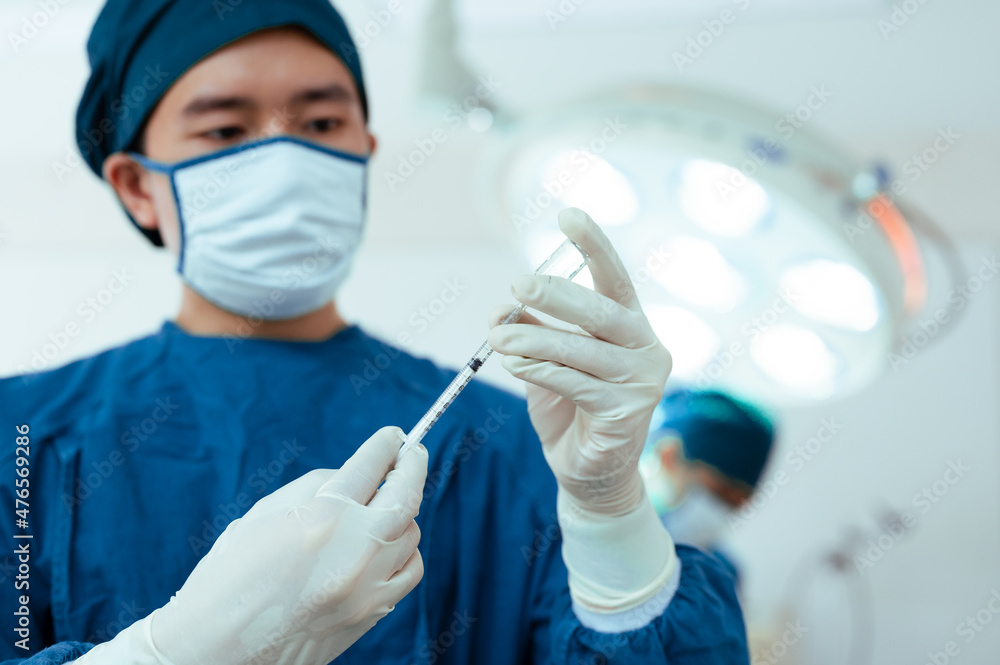Team of doctors wearing protective clothing works together to monitor patients in Bright Modern operating room. Surgery on patients lying on patient beds. resuscitation of the wounded. Team of doctors wearing protective clothing works together to monitor patients in Bright Modern operating room. Surgery on patients lying on patient beds. resuscitation of the wounded.