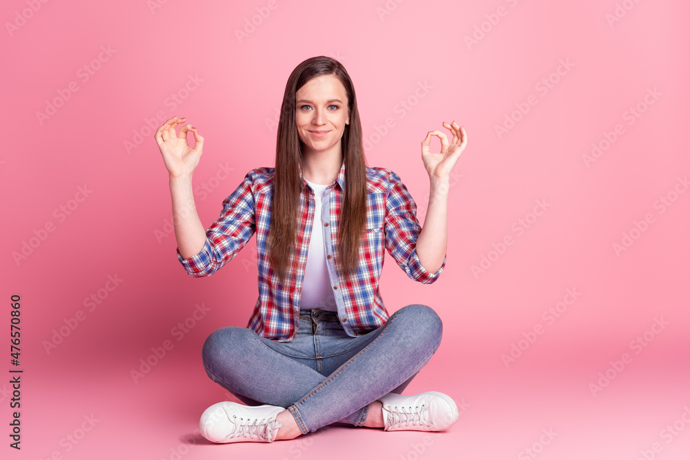 Full size photo of young pretty woman good mood sit floor show fingers okey symbol isolated over pink color background Full size photo of young pretty woman good mood sit floor show fingers okey symbol isolated over pink color background