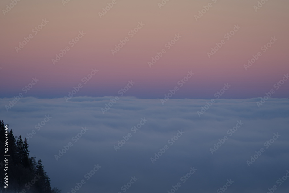 Beautiful colored morning sky at mountain village Stoos with sea of fog in the foreground at wintertime. Photo taken December 21st, 2021, Stoos, Switzerland.