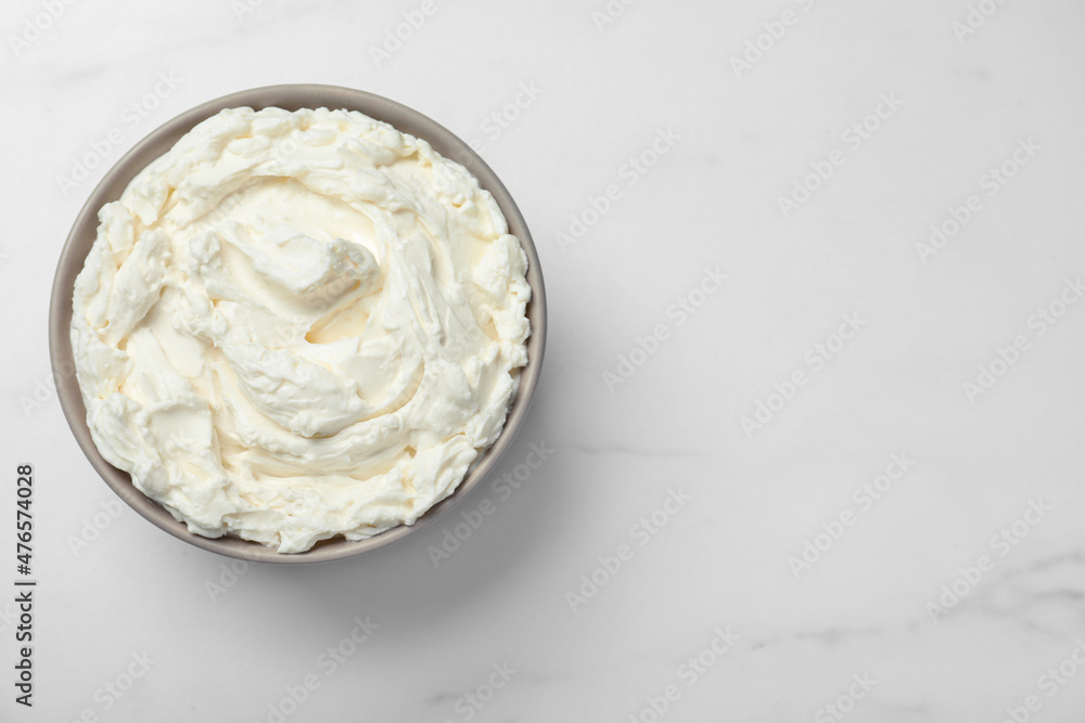 Bowl of tasty cream cheese on white table, top view. Space for text Bowl of tasty cream cheese on white table, top view. Space for text