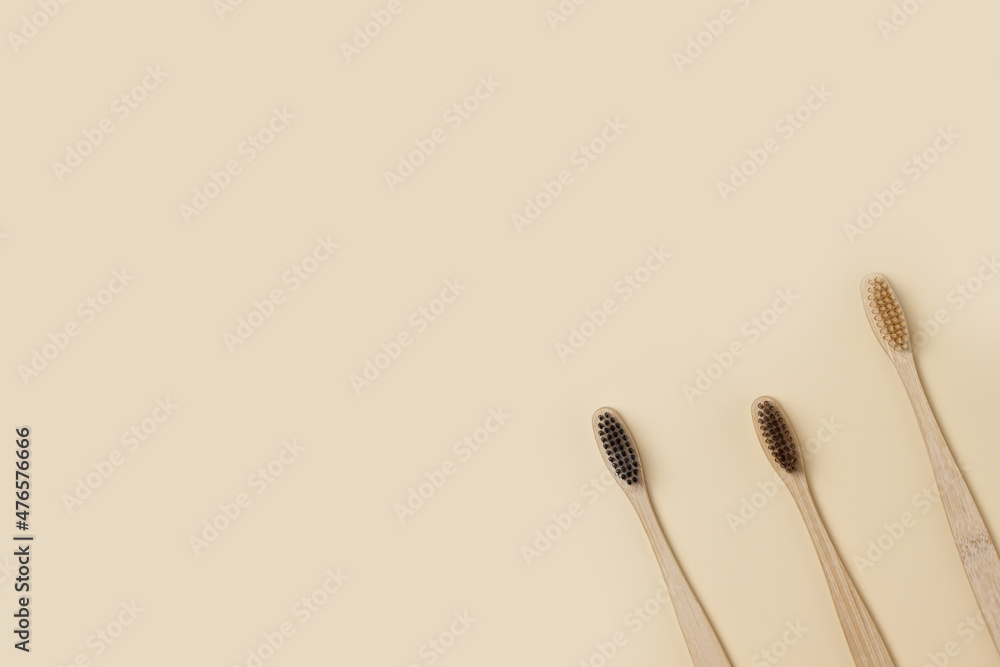 Bamboo wooden three toothbrushes on a beige background. Cleanliness and hygiene of the dental cavity. Minimalism, ecology, no waste and environmental friendliness. copyspace Bamboo wooden three toothbrushes on a beige background. Cleanliness and hygiene of the dental cavity. Minimalism, ecology, no waste and environmental friendliness. copyspace