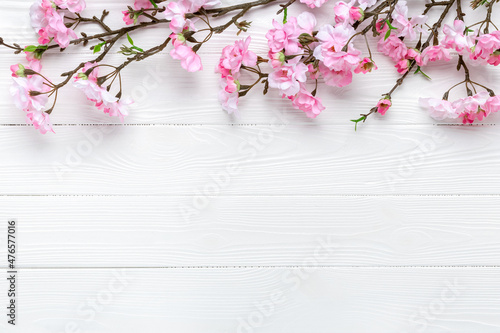 Cherry blossom on a white wood background. Floral frame border. Template with copy space. Romantic pattern with place for text. Mockup. Spring layout. Mother's day greeting card. Sakura branches.