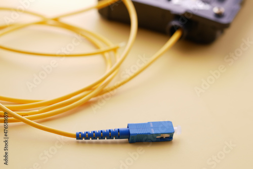Wi-Fi router with cables on yellow background 