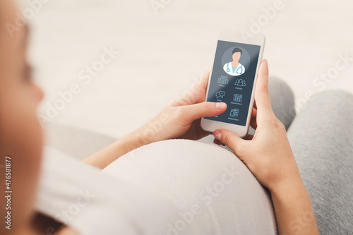 Pregnant lady using online medical service on mobile phone