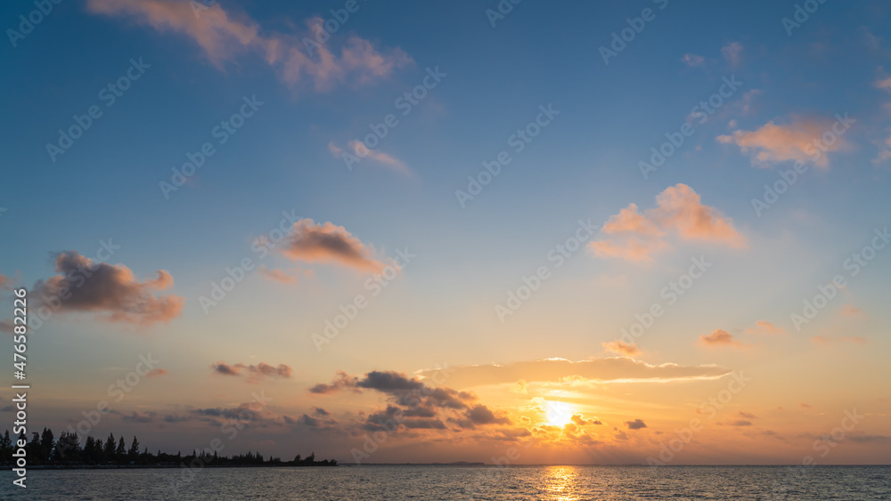 Sunset sky over sea in the evening with colorful orange sunlight clouds, Dusk sky background