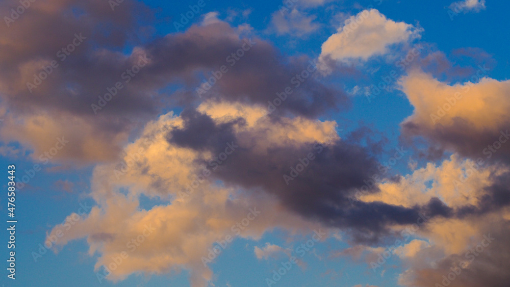 Passages nuageux pendant le coucher du soleil.  Les nuages arborent une teinte orangée