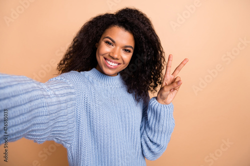 Photo of young cheerful girl take selfie show peace cool v-symbol isolated over beige color background