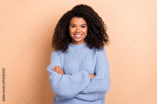 Photo of young attractive cheerful woman crossed hands intelligent isolated over beige color background