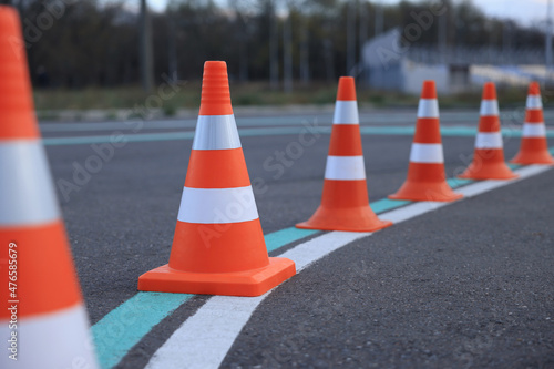Driving school test track with marking lines, focus on traffic cone photo