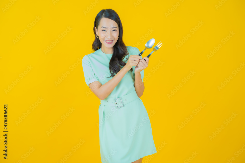 Portrait beautiful young asian woman smile with spoon and fork Portrait beautiful young asian woman smile with spoon and fork