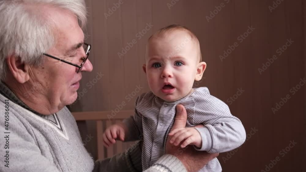Family Relations of Elderly 60s Male and Baby Girl. Happy Old Man Holds a little Child on Hands. Gentle Hug and Love for Caucasian Grandchild in Slow Motion. Enjoy Family Time.
Family Relations of Elderly 60s Male and Baby Girl. Happy Old Man Holds a little Child on Hands. Gentle Hug and Love for Caucasian Grandchild in Slow Motion. Enjoy Family Time.