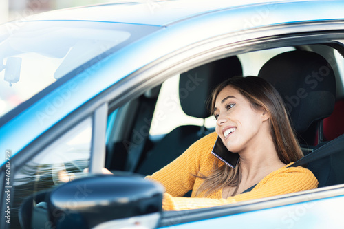 Brown hair happy Woman talking on the phone while driving a car.