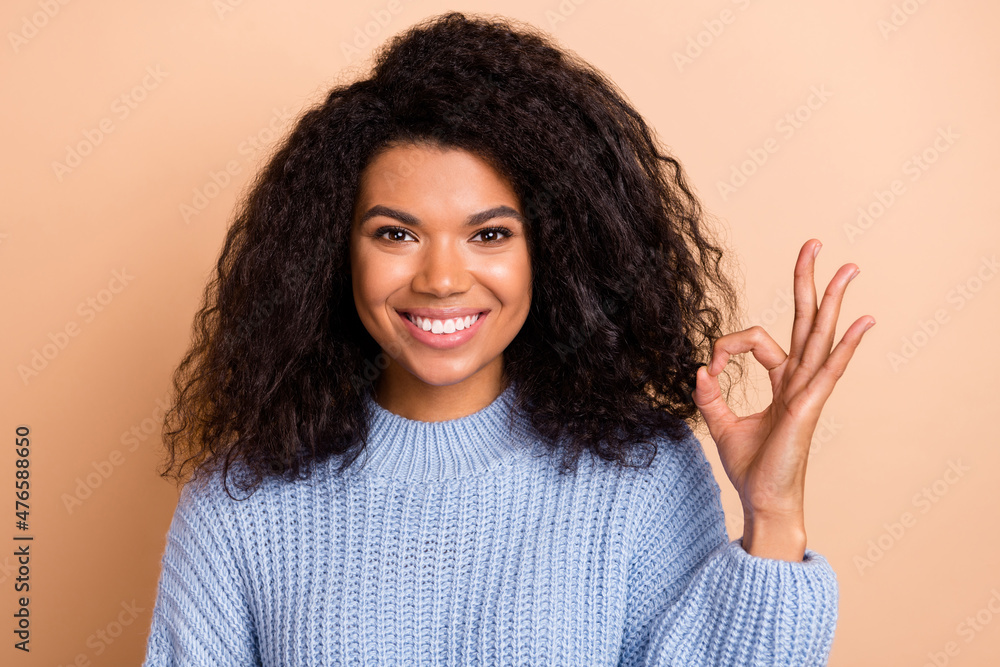 Photo of young pretty woman show fingers okey symbol promo decision ads isolated over beige color background Photo of young pretty woman show fingers okey symbol promo decision ads isolated over beige color background