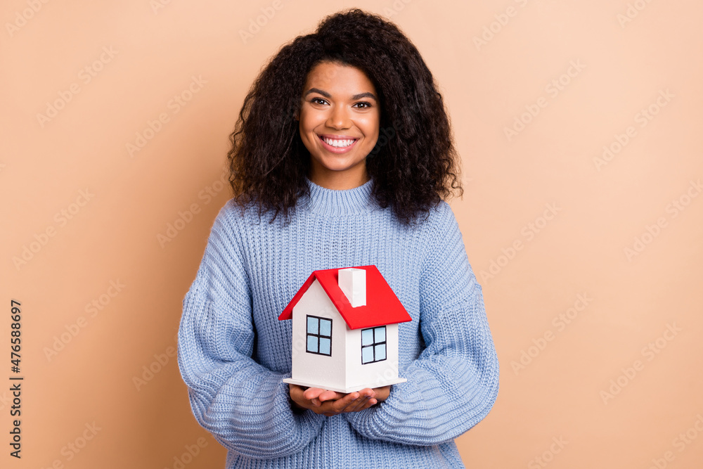 Photo of young lovely woman safe protection buy new home advertise manager isolated over beige color background Photo of young lovely woman safe protection buy new home advertise manager isolated over beige color background